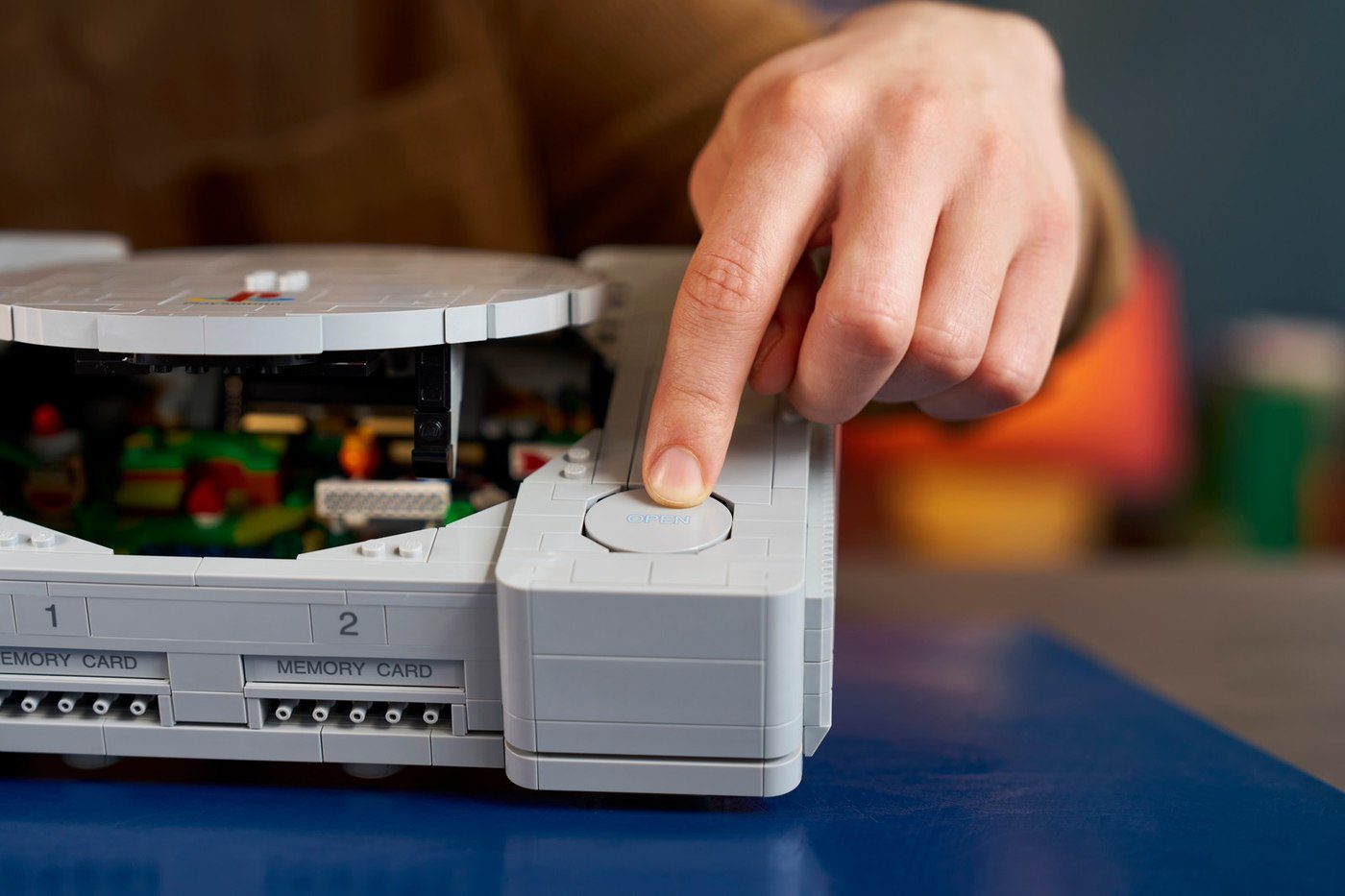 Finger pressing the functional Open button on the LEGO PlayStation 72306